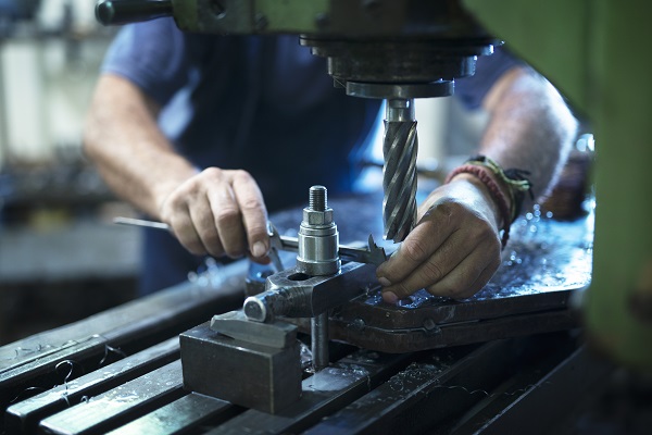 Operaio specializzato lavora ad un macchinario per le lavorazioni meccaniche.
